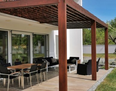 Vue sur une table et des chaises de jardin sous une pergola en bois