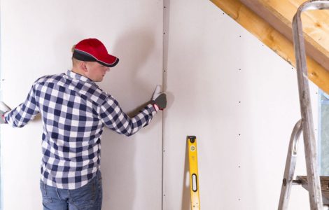 Un homme en casquette pose une cloison