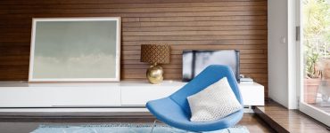 Chaise design bleu dans un salon avec des revêtements muraux en boiseries horizontales