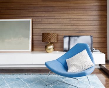 Chaise design bleu dans un salon avec des revêtements muraux en boiseries horizontales
