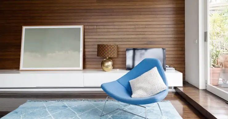 Chaise design bleu dans un salon avec des revêtements muraux en boiseries horizontales