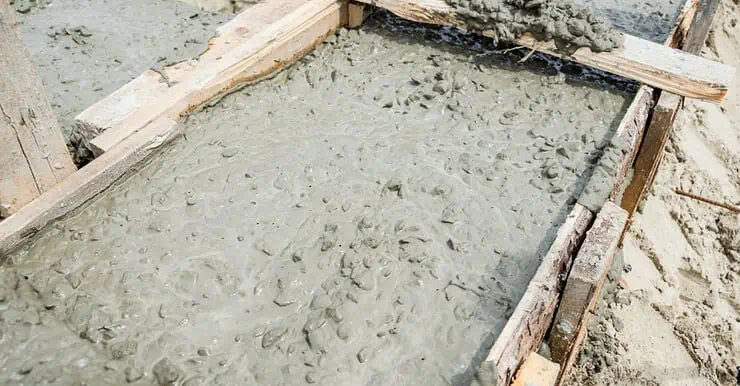 Du béton frais coulé dans le coffrage d’un chantier