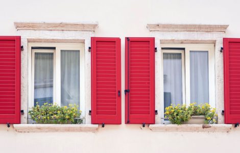 Deux fenêtres italiennes avec volets classiques de couleur rouge vif