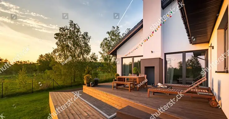 Une maison moderne avec une terrasse en bois et des meubles de jardin en bois