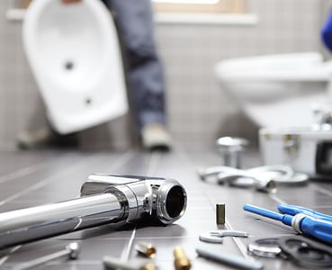 Focus sur les outils et les pièces de plomberie d'un plombier au travail dans une salle de bain