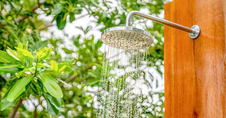 Un pommeau de douche installé à l’extérieur laissant couler l’eau