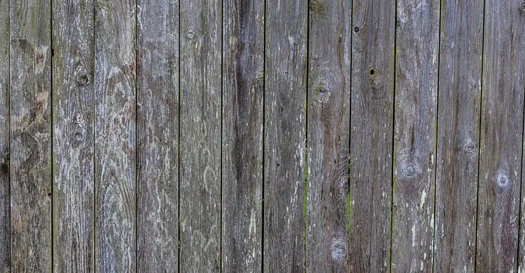 Une vieille clôture en bois qui a noirci