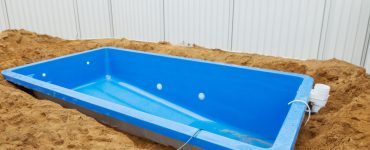 Installation d'une piscine en plastique bleu dans le sol