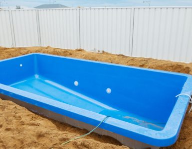 Installation d'une piscine en plastique bleu dans le sol