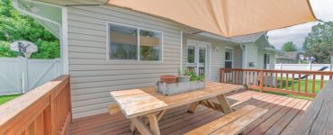 Table de jardin sur la terrasse en bois avec un voile d'ombrage