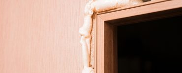 Zoom sur une couche de mousse polyuréthane insérée dans les trous autour de la porte