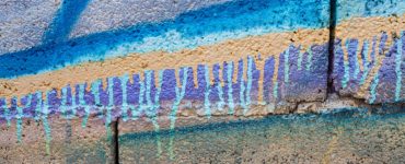 Du graffiti peint en spray de couleur vive sur un mur en pierre