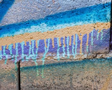 Du graffiti peint en spray de couleur vive sur un mur en pierre