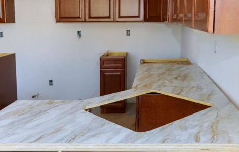 Vue sur les meubles de cuisine en bois dont l’installation n’est pas totalement terminée