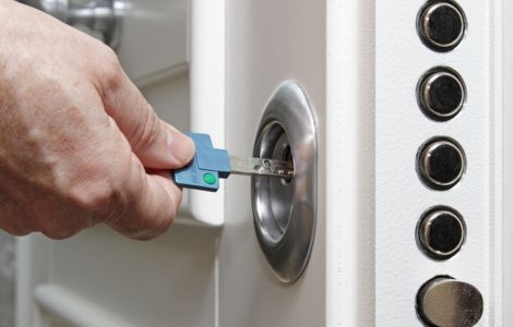 Gros plan sur les mains d'un homme ouvrant la porte blindée de sa maison