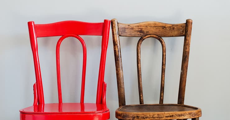 Une paire de chaises en bois, avec une en rouge