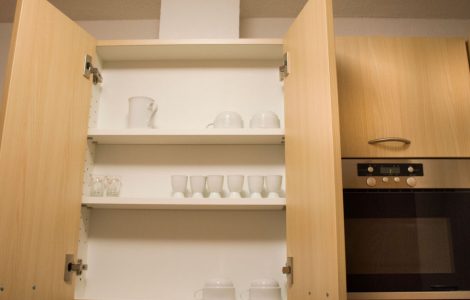 Placard de cuisine en bois avec des tasses blanches à l'intérieur