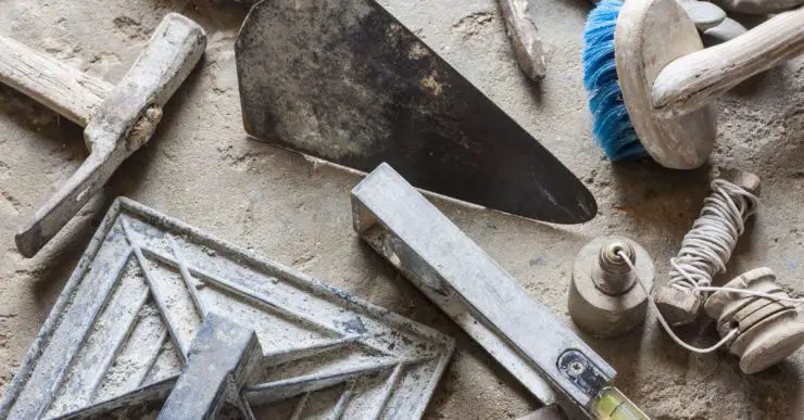 Différents outils du maçon posés sur le sol