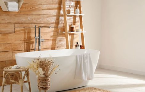 Une baignoire blanche dans une salle de bains avec bardage en bois