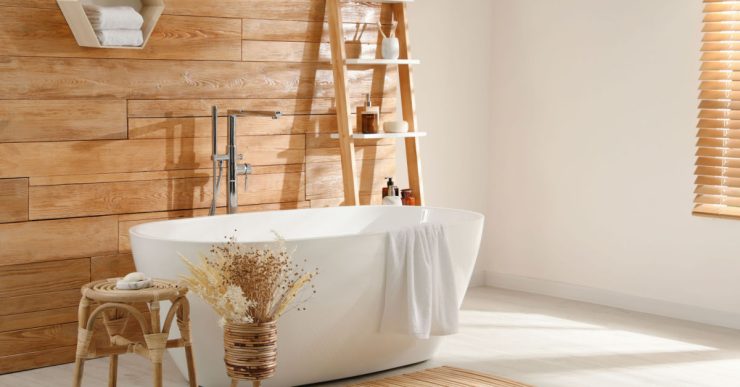 Une baignoire blanche dans une salle de bains avec bardage en bois