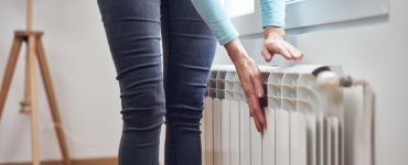 Une femme se chauffant les mains sur le radiateur