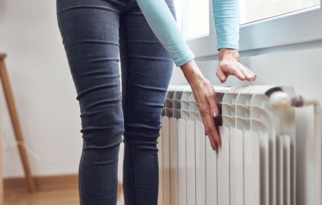 Une femme se chauffant les mains sur le radiateur