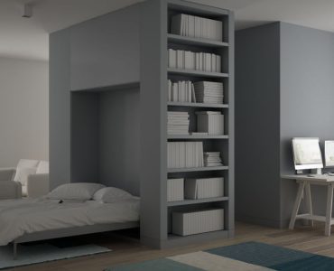 Une chambre grise avec un lit escamotable et un coin bureau