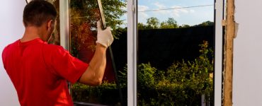 Un homme installant du verre dans le cadre d'une fenêtre