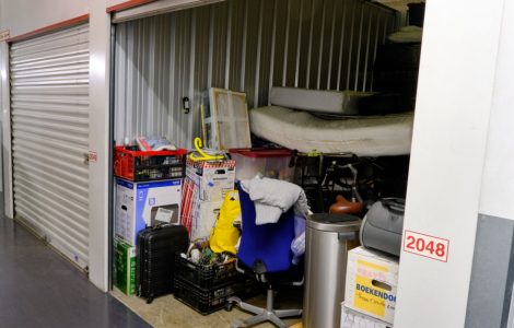 Un box ouvert avec des meubles et des cartons dans un lieu d’entreposage commun