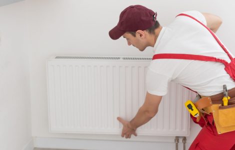 Un plombier réparant le radiateur de la maison