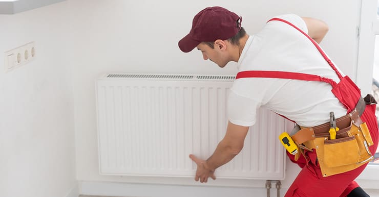 Un plombier réparant le radiateur de la maison