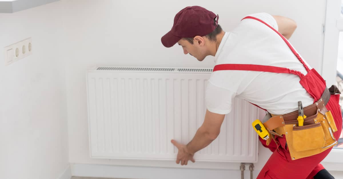 Un plombier réparant le radiateur de la maison