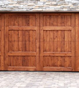 Porte de garage en bois sur un mur en fausse pierre