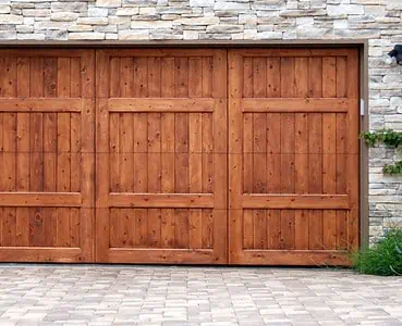 Porte de garage en bois sur un mur en fausse pierre