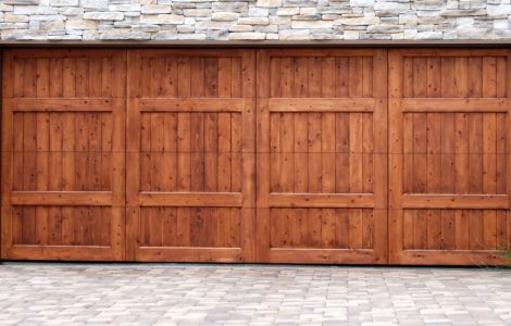 Porte de garage en bois sur un mur en fausse pierre