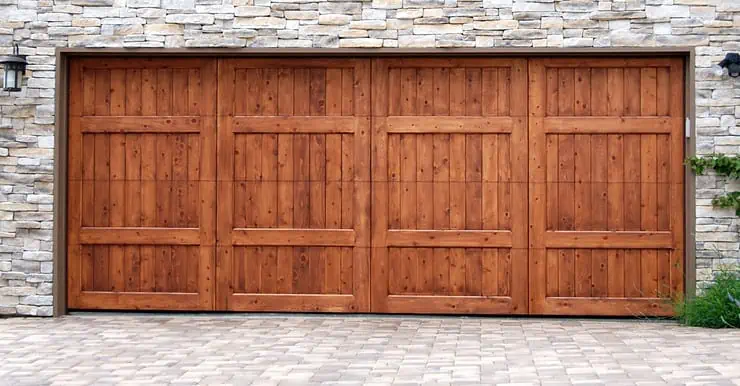 Porte de garage en bois sur un mur en fausse pierre