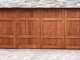 Porte de garage en bois sur un mur en fausse pierre