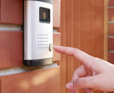 Zoom sur la main de la femme appuiant sur un bouton de l'interphone avec caméra