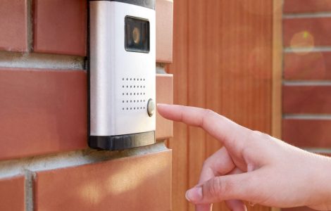 Zoom sur la main de la femme appuiant sur un bouton de l'interphone avec caméra