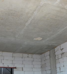 Vue intérieure d'une pièce vide d’une maison en construction avec les murs et le plafond sans finition