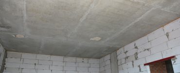 Vue intérieure d'une pièce vide d’une maison en construction avec les murs et le plafond sans finition