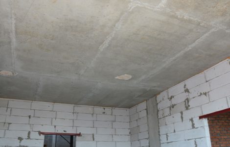 Vue intérieure d'une pièce vide d’une maison en construction avec les murs et le plafond sans finition
