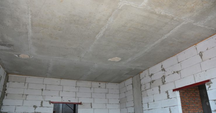 Vue intérieure d'une pièce vide d’une maison en construction avec les murs et le plafond sans finition