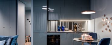 Maison moderne avec cuisine ouverte bleue et petit coin repas avec table ronde