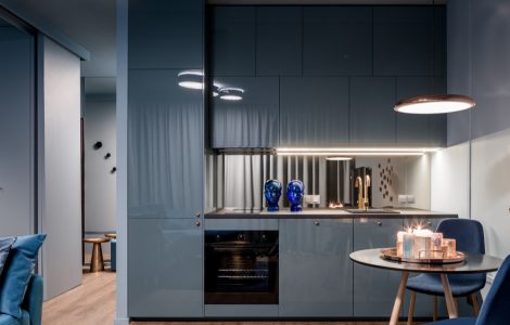 Maison moderne avec cuisine ouverte bleue et petit coin repas avec table ronde