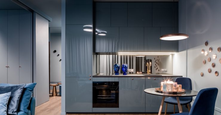 Maison moderne avec cuisine ouverte bleue et petit coin repas avec table ronde