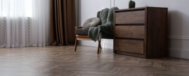 Une chaise et un meuble en bois posés dans un salon en parquet