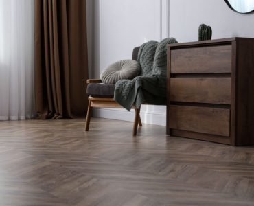 Une chaise et un meuble en bois posés dans un salon en parquet