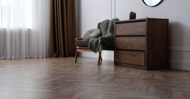 Une chaise et un meuble en bois posés dans un salon en parquet