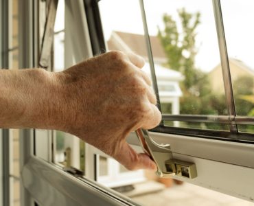 Zoom sur la main d'un homme ouvrant une fenêtre